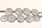 Vintage Navajo sterling silver concho belt with ornate hand-stamped conchos featuring central lapis lazuli stones set on a brown leather strap, an authentic Native American southwestern accessory.