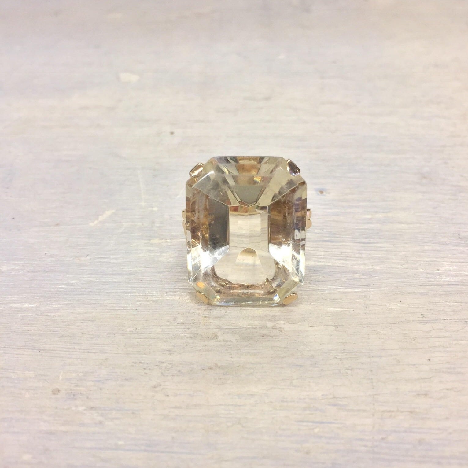 14 karat gold emerald cut solitaire ring on light background