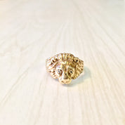 Vintage 10K gold lion head ring with diamond accents, a bold retro statement piece showcasing intricate craftsmanship and eye-catching design in a close-up view against a light wooden background.