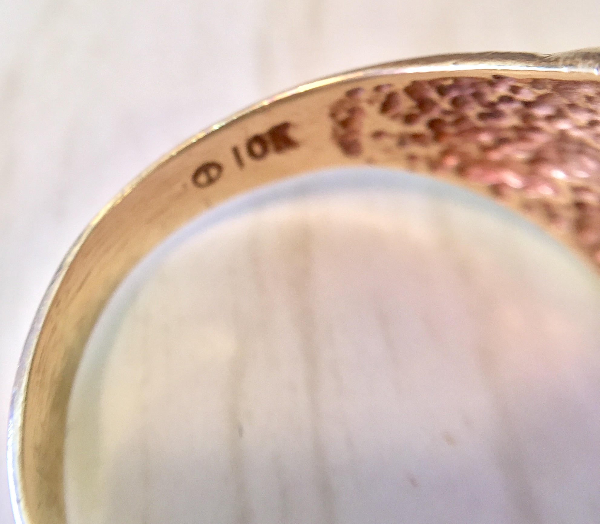 Vintage 10K gold lion head ring with diamond accents, close-up view showing intricate details and craftsmanship of the lion's face on the band.