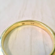18K yellow gold stacking ring with thin, sleek design, ideal for use as a simple wedding band or minimalist jewelry piece.