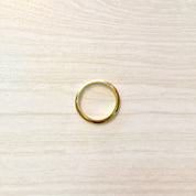 18K yellow gold stacking ring on light wood background