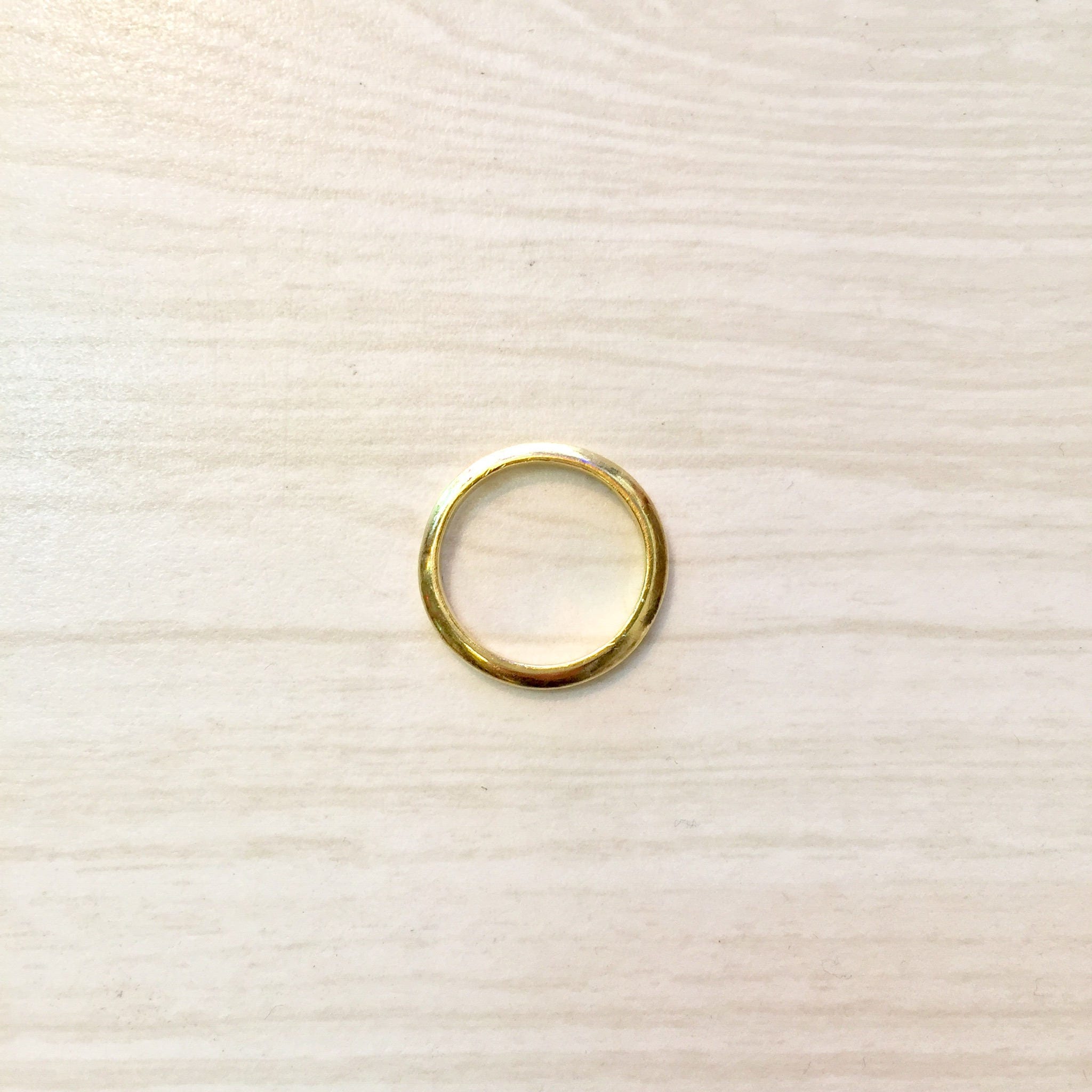 18K yellow gold stacking ring on light wood background