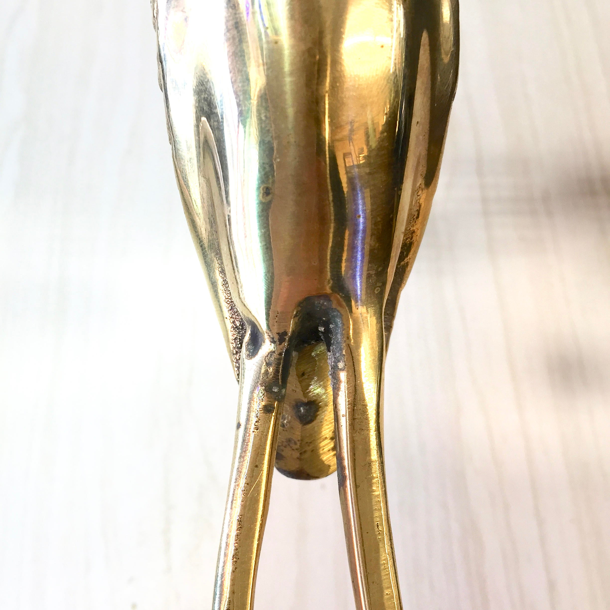 Vintage brass crane statue with iridescent patina, depicting a standing bird figurine in midcentury modern style, serving as elegant brass home decor or gift idea.