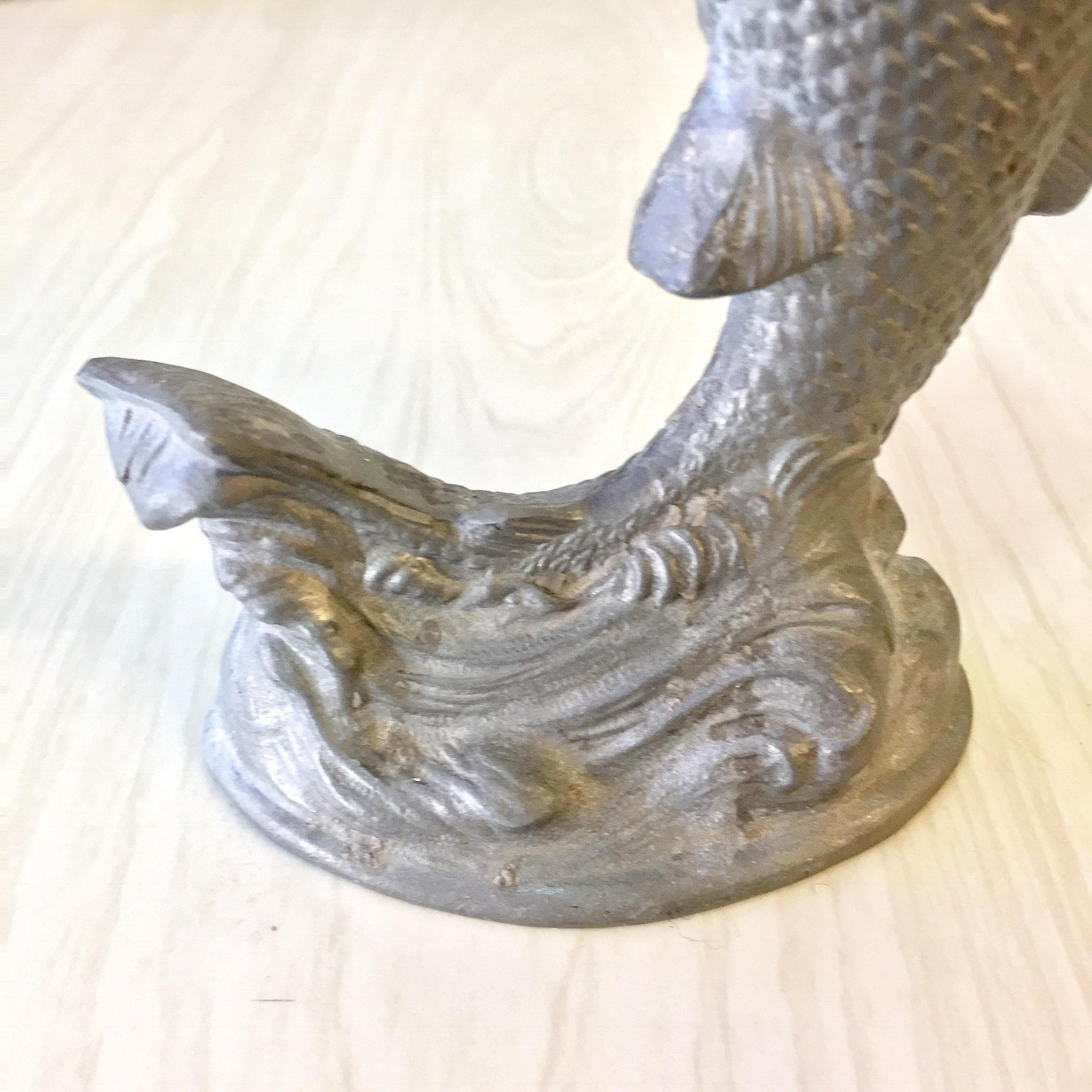 Vintage pewter fish candlestick holder with intricate scale and fin details, making a unique housewarming or holiday gift for antique home decor enthusiasts.