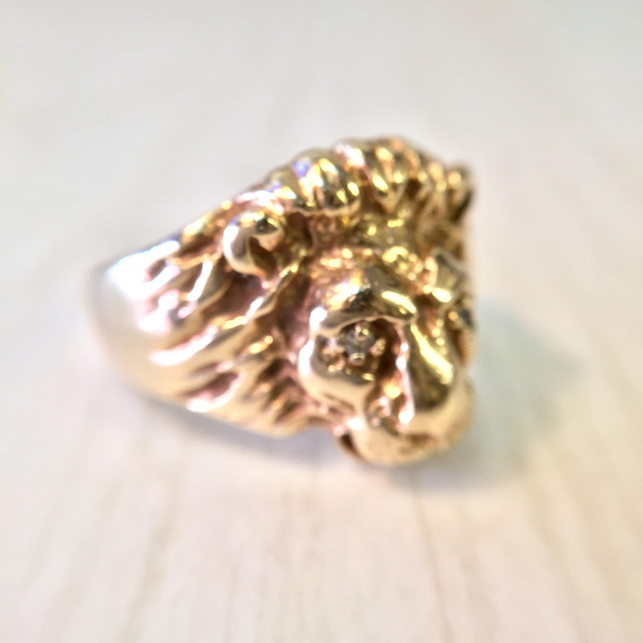 Vintage 10K gold lion head ring with diamond accents, featuring an intricate lion's head design as a bold statement piece from a retro era of jewelry fashion.