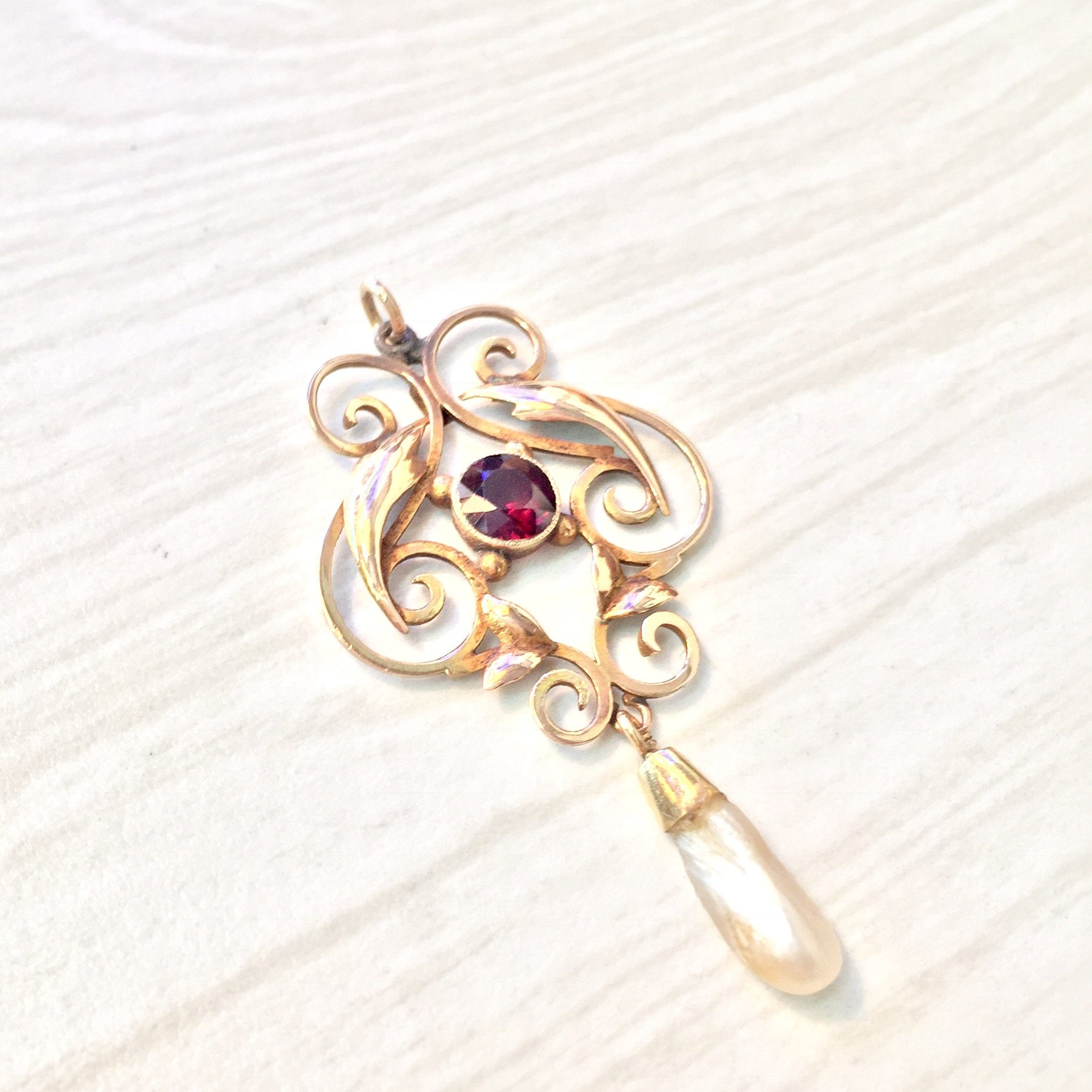 Antique 10K gold pendant featuring intricate swirl design with a dangling teardrop fresh water pearl and a purple amethyst gemstone accent.