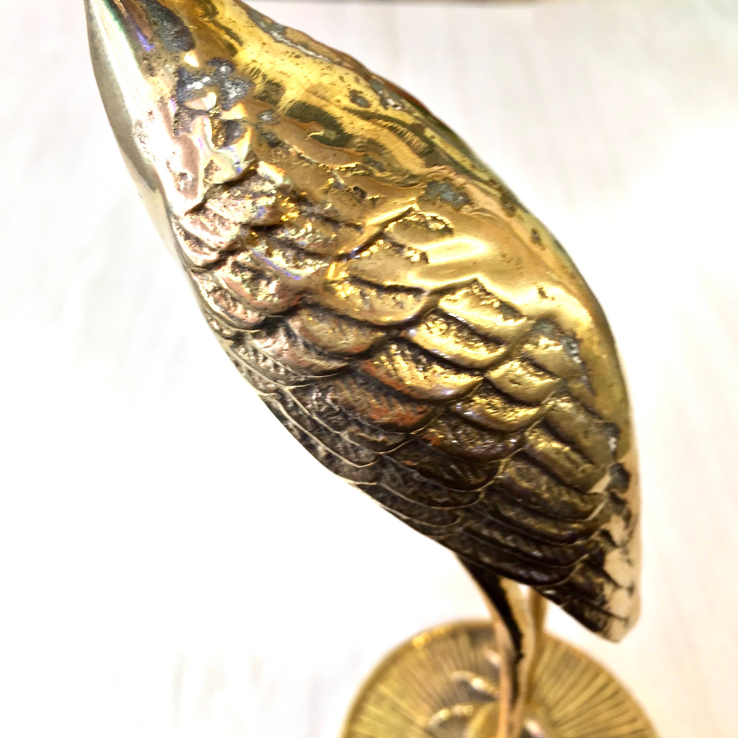 Vintage brass crane statue with detailed feather textures and shiny gold finish, mounted on round brass base. Midcentury modern style brass bird figurine for home decor or gift.