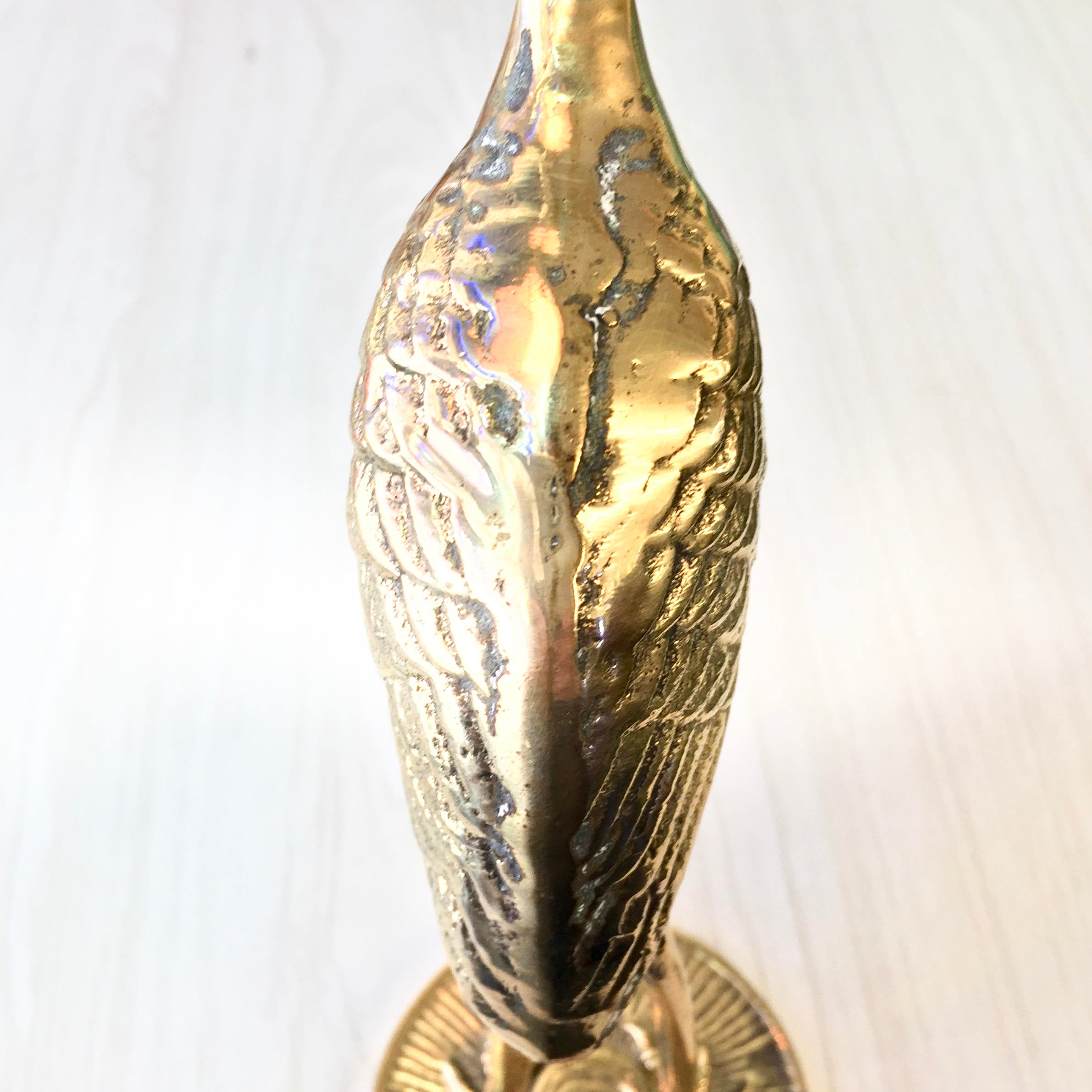 Vintage brass crane statue with detailed feather texture and patina. Midcentury modern style brass bird figurine for home decor.