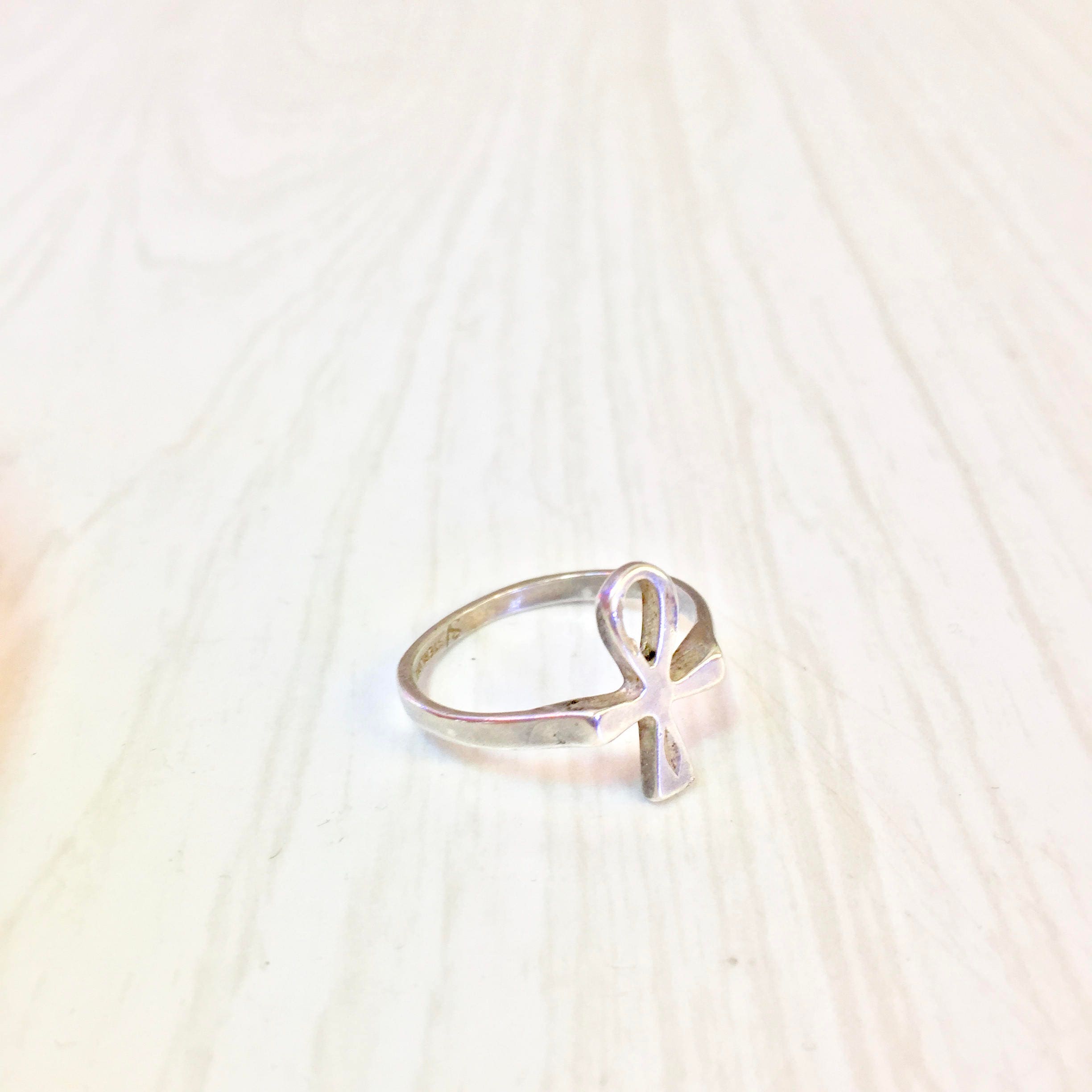 Vintage sterling silver ankh ring on light wooden background