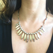Vintage sterling silver bib necklace with pointed oval pendants worn on a woman's neck and chest.