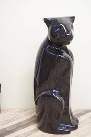 Tall black ceramic Royal Haeger panther statue from the 1970s with glossy glaze finish, depicting a sitting panther, used as vintage home decor.