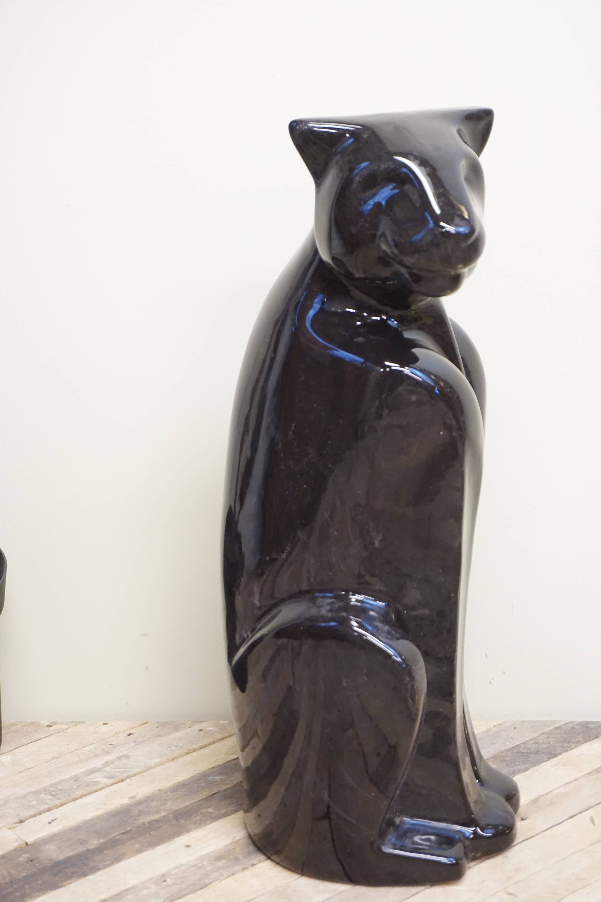 Tall black ceramic Royal Haeger panther statue from the 1970s with glossy glaze finish, depicting a sitting panther, used as vintage home decor.