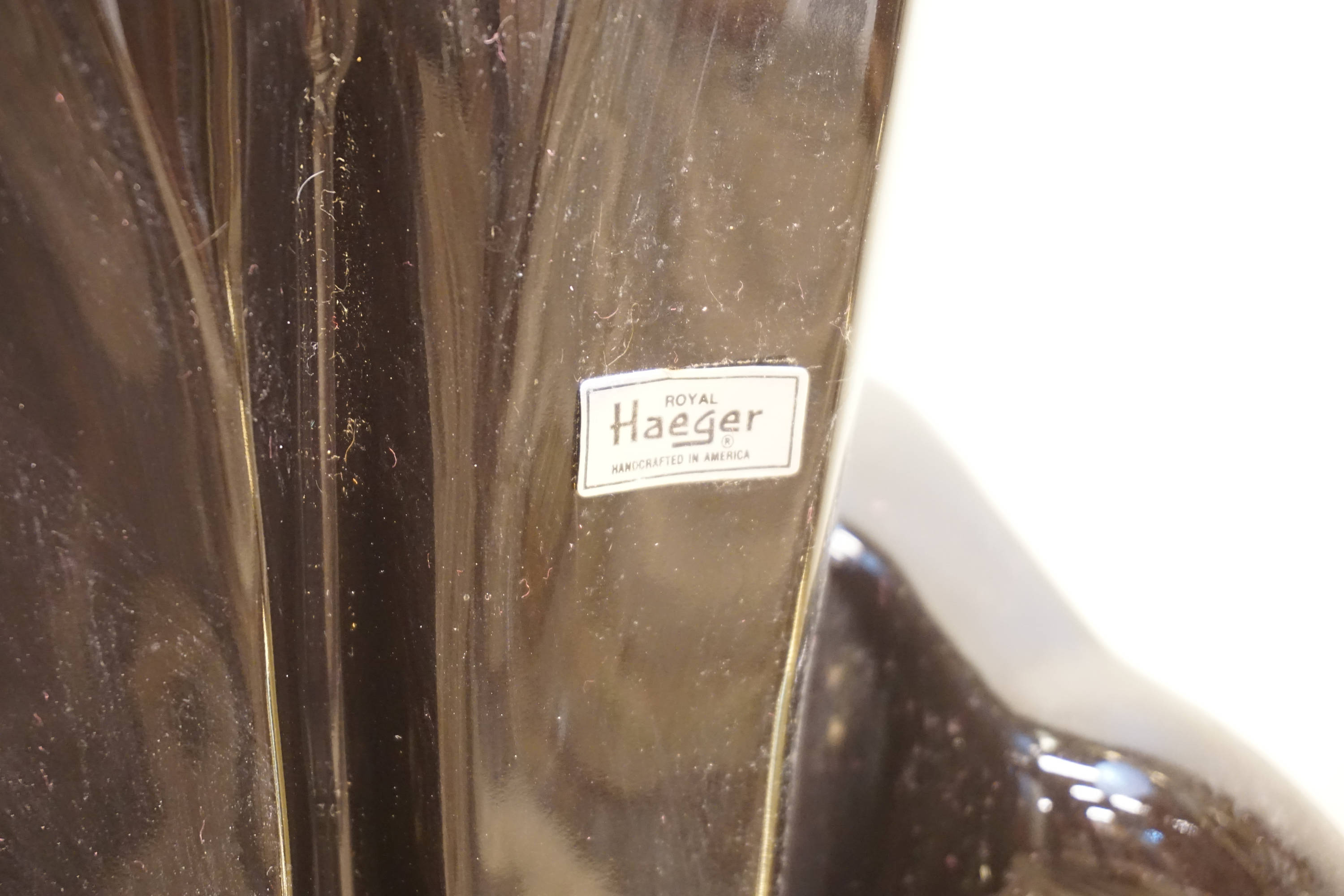 Closeup of a vintage Royal Haeger ceramic panther statue label, showing dust and imperfections from age.