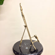 Vintage brass easel book holder stand with intricate filigree design, ideal for displaying cookbooks or decor items in a boho chic style home.
