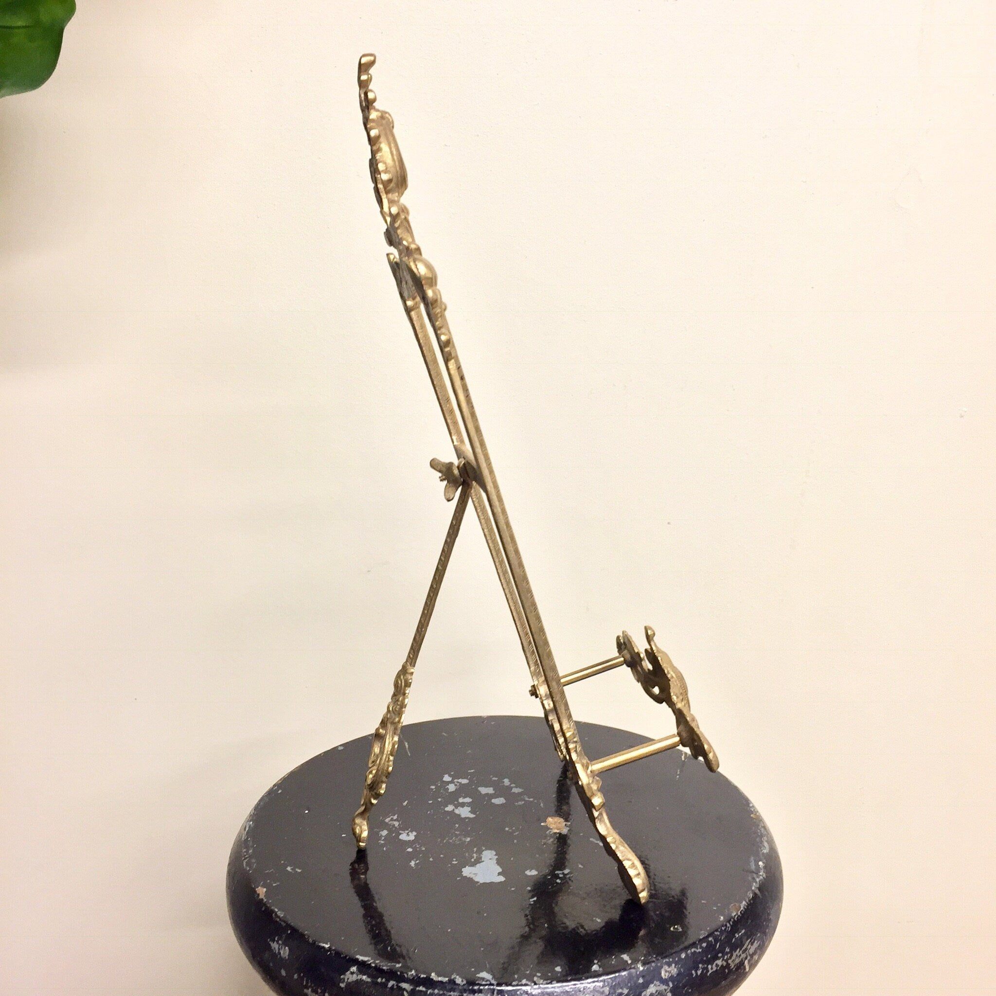 Vintage brass easel book holder stand with intricate filigree design, ideal for displaying cookbooks or decor items in a boho chic style home.