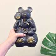 Large vintage black and gold ceramic sake bottle shaped like a rat or mouse holding smaller bottles, with a green plant leaf, unique Asian home decor