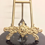 Ornate vintage brass easel book holder with intricate filigree design, suitable for displaying cookbooks or frames in bohemian chic home decor.