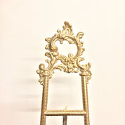 Ornate vintage brass easel with intricate filigree design, ideal for displaying books, cookbooks, or frames in a bohemian chic home decor style.