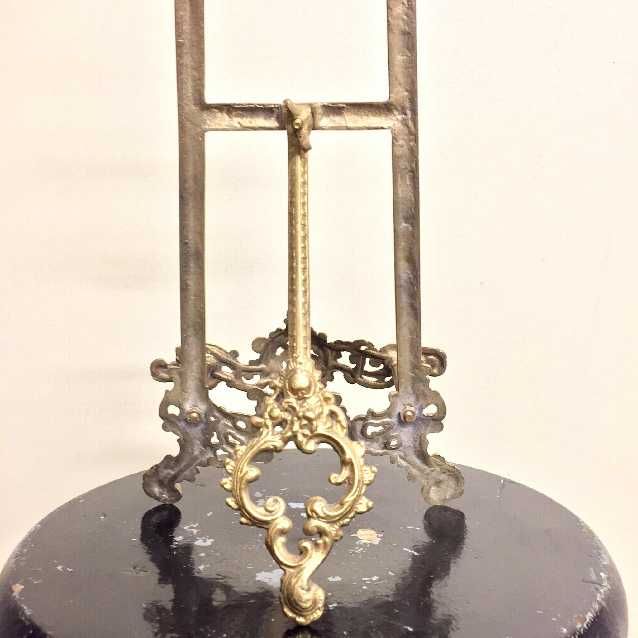 Antique brass easel with ornate filigree design, used as a cookbook stand or decorative book holder for vintage boho chic home decor.