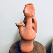 Terracotta clay planter shaped like an abstract human figure with openings for growing strawberry plants or herbs. The rustic ceramic sculpture has an organic, handmade appearance.
