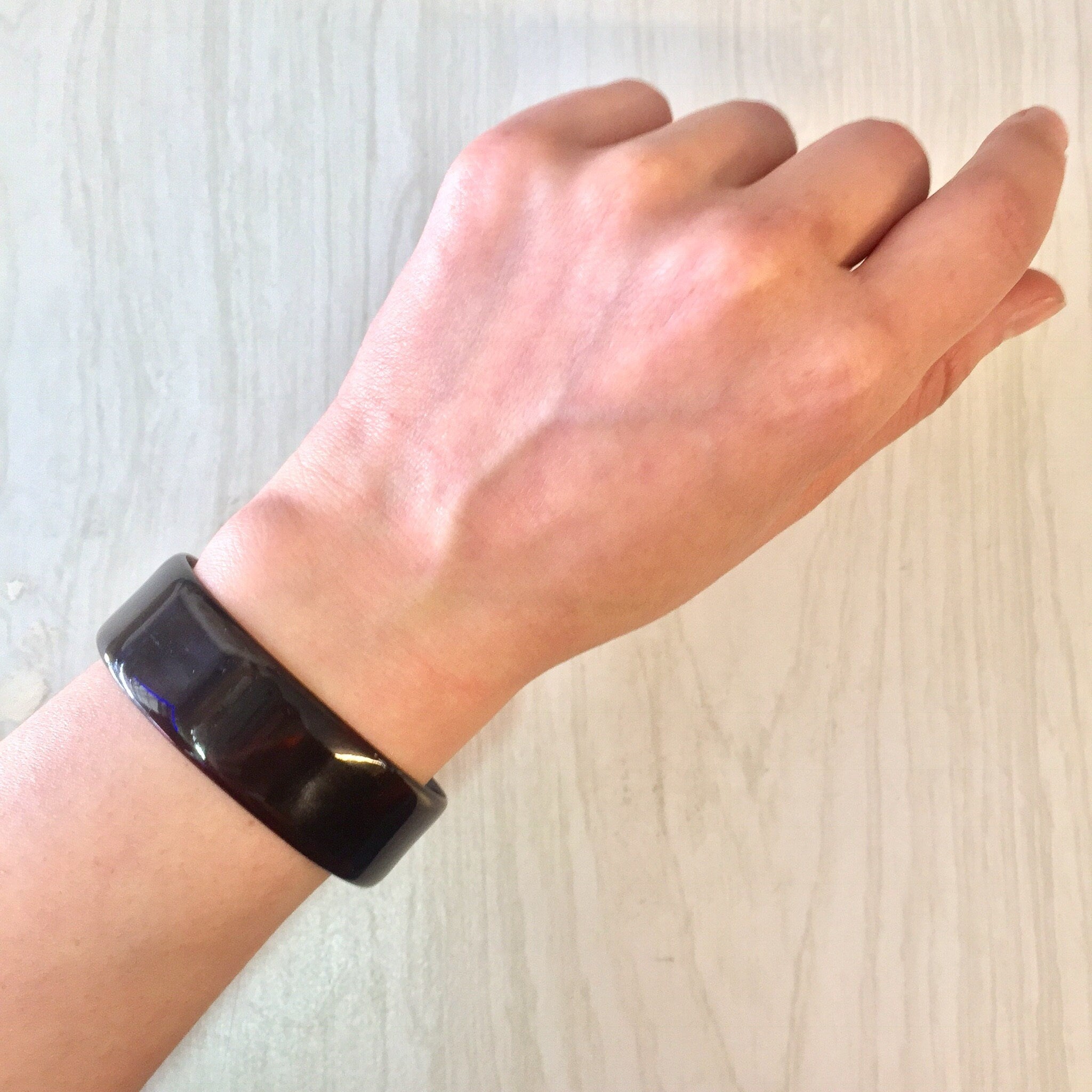 Brown tortoise shell plastic cuff bracelet on wrist, vintage costume jewelry