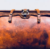 Vintage brown leather handbag with leather strap and metal closure, well-worn patina, rustic bohemian style purse from the 1960s era