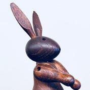 Vintage wooden rabbit toy carving with pointy ears and dark finish, a collectible animal decor piece and bunny figurine