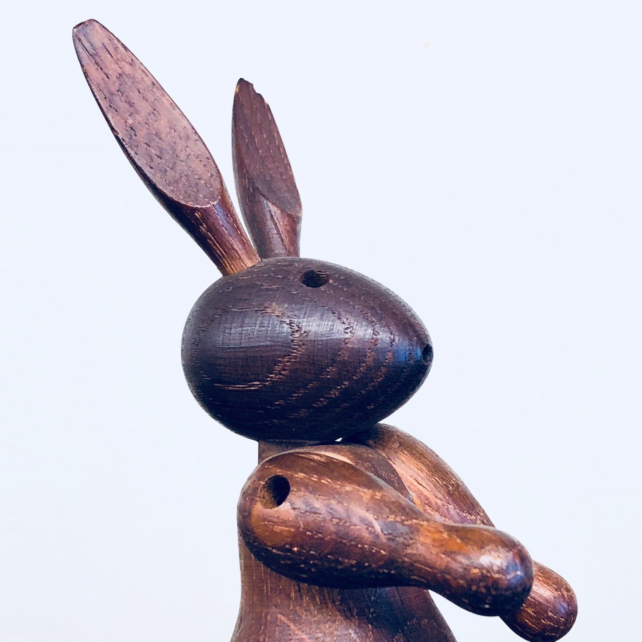Vintage wooden rabbit toy carving with pointy ears and dark finish, a collectible animal decor piece and bunny figurine