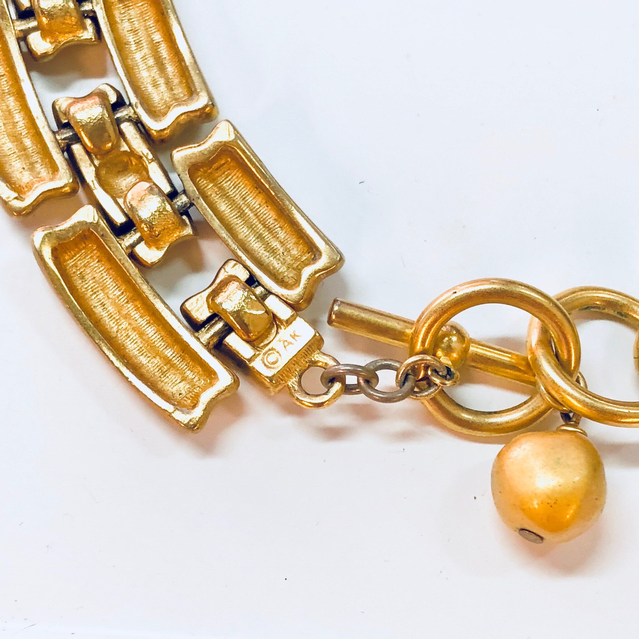 Vintage gold-toned Anne Klein chain link choker necklace with toggle closure and decorative pendant charm.