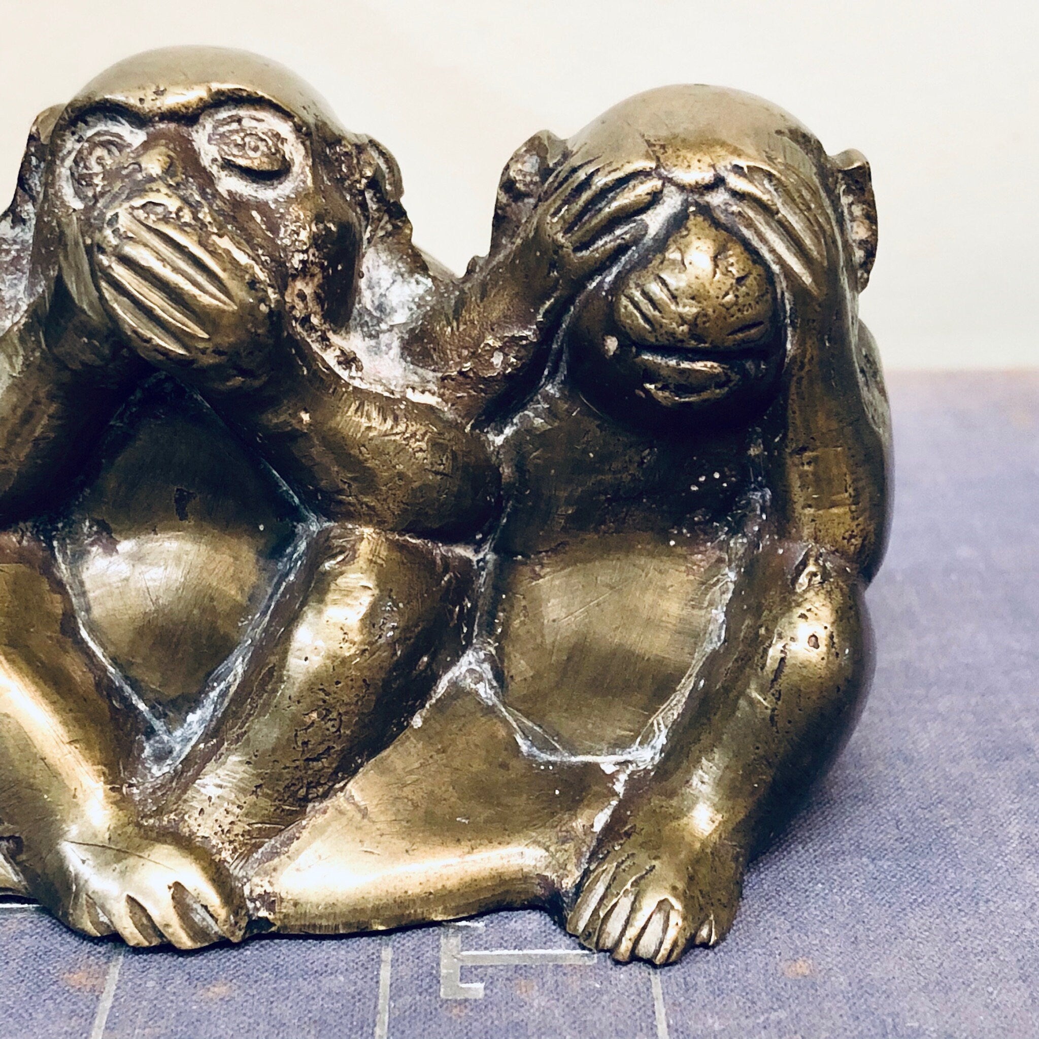 Three brass monkey figurines depicting "see no evil, hear no evil, speak no evil" pose, vintage home decor