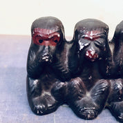 Three black ceramic monkey figurines with red eyes depicting the "hear no evil, see no evil, speak no evil" proverb, vintage Japanese home decor.