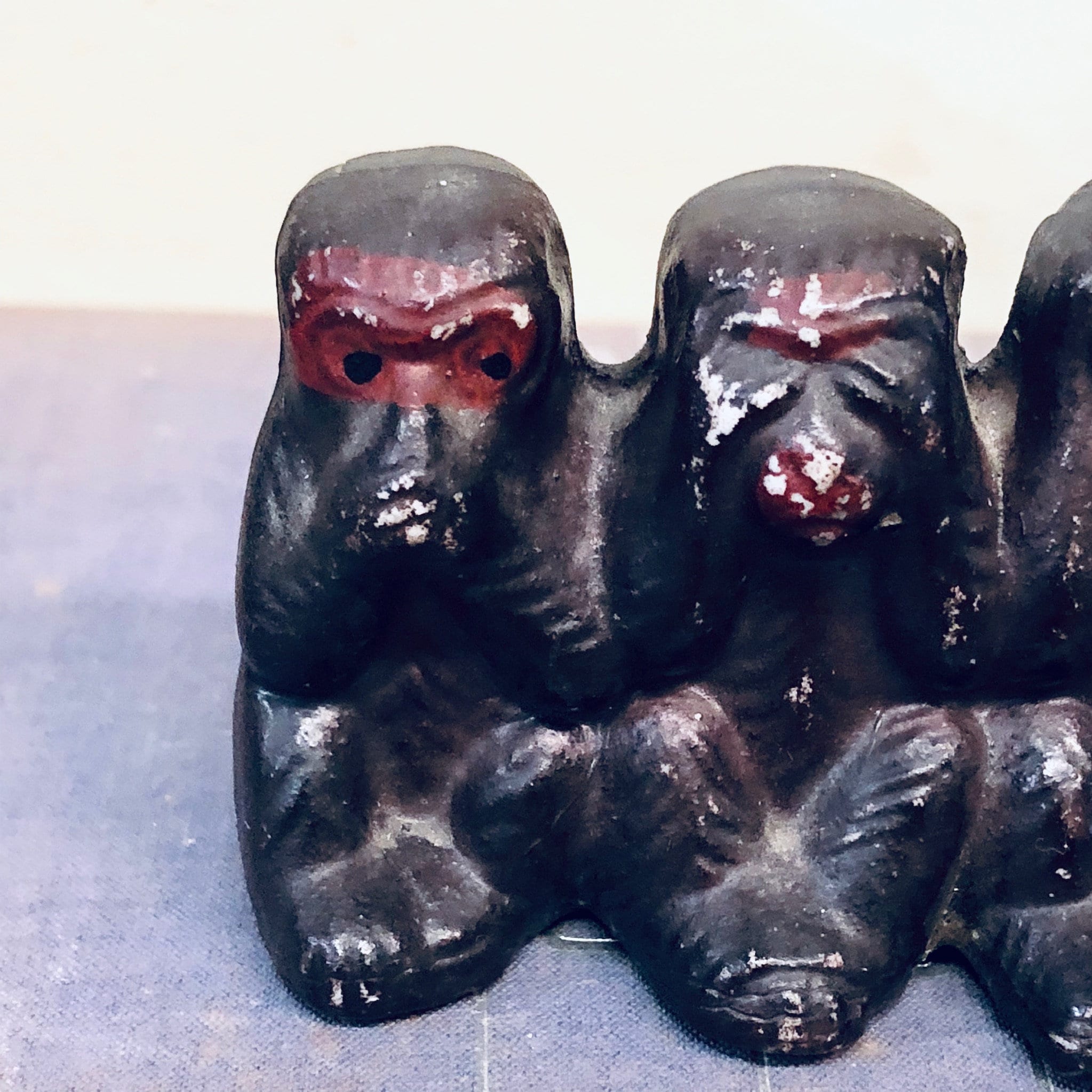 Three black ceramic monkey figurines with red eyes depicting the "hear no evil, see no evil, speak no evil" proverb, vintage Japanese home decor.