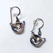 Vintage silver cut out cat face dangle earrings on white background