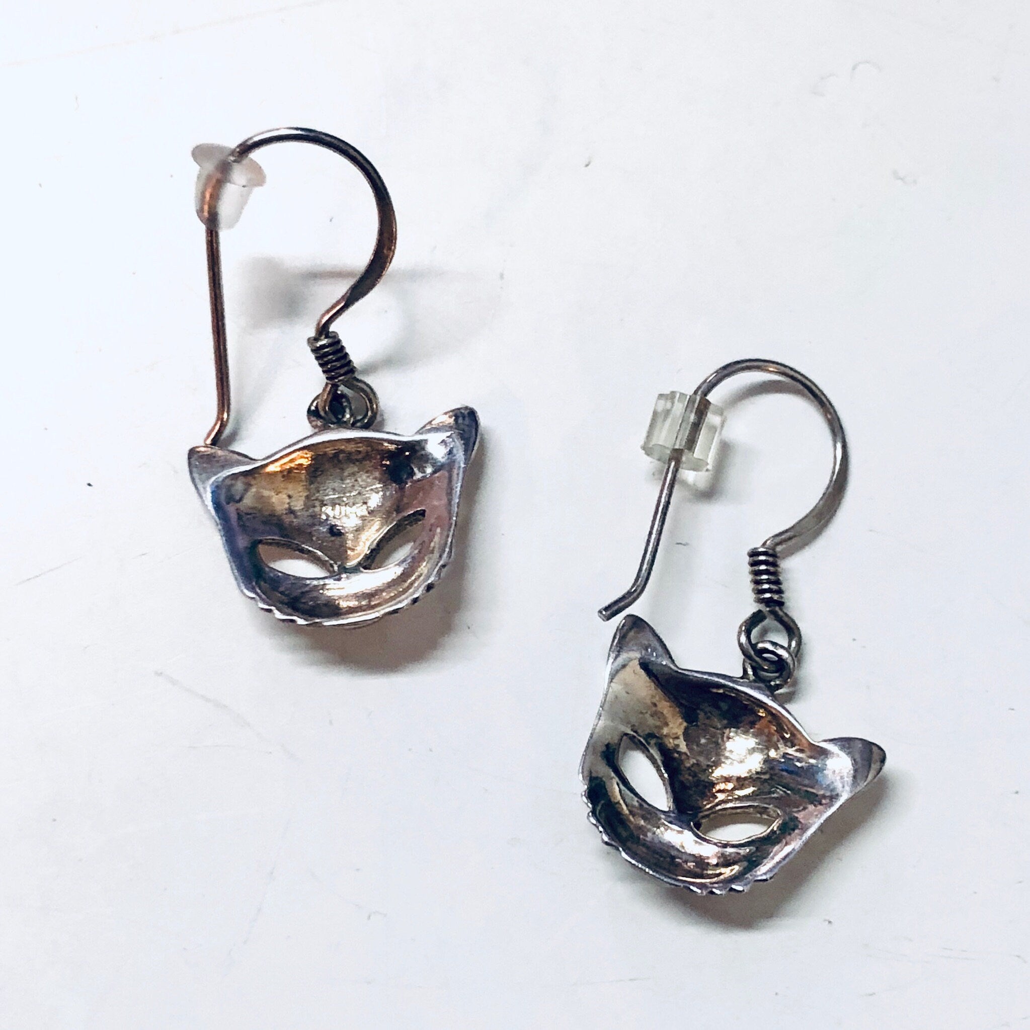 Vintage silver cut out cat face dangle earrings on white background