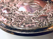 Vintage sterling silver compact mirror with intricate floral engraving and patina, crafted by Towle Silversmiths, featuring a monogram on the reflective surface.