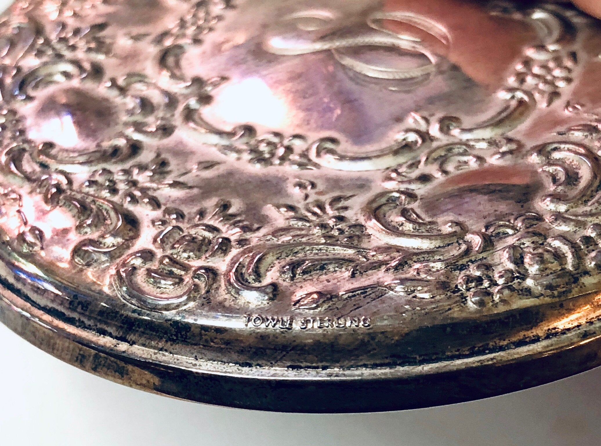 Vintage sterling silver compact mirror with intricate floral engraving and patina, crafted by Towle Silversmiths, featuring a monogram on the reflective surface.