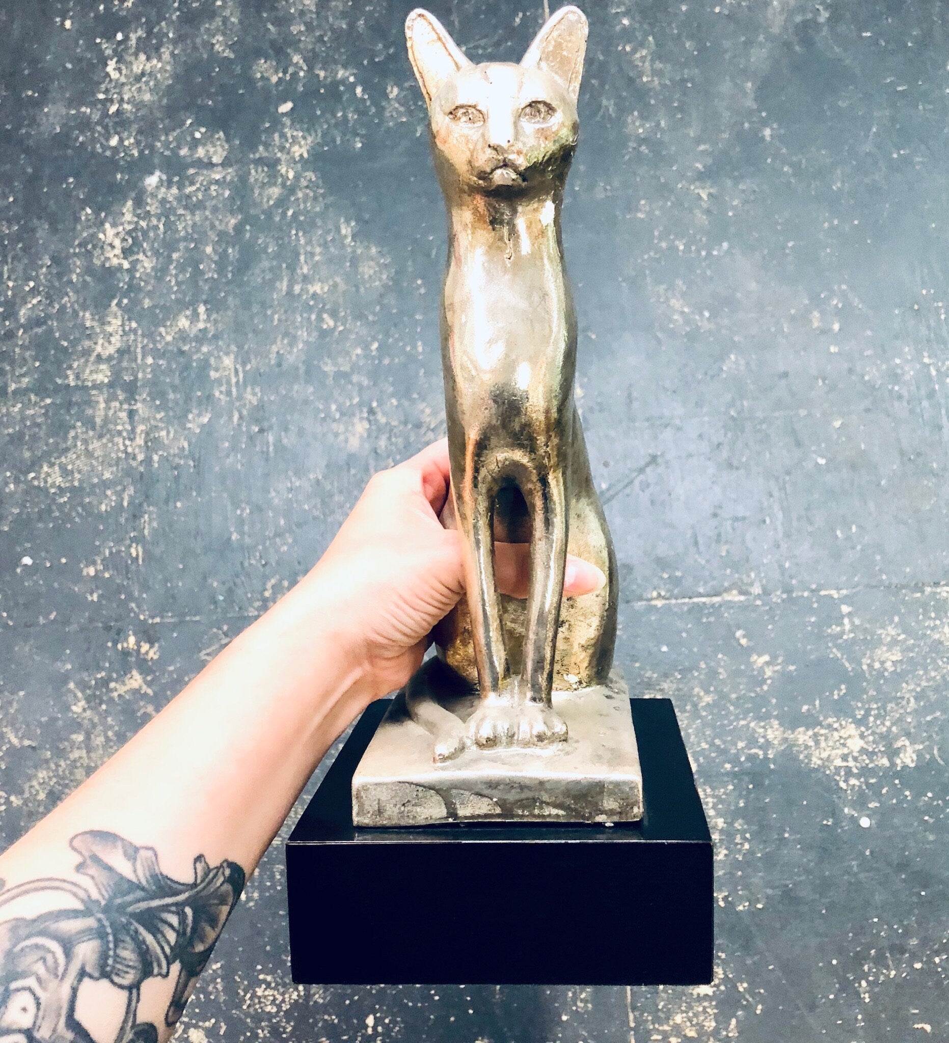 Vintage silver cat statue sculpture on black base, standing elegantly with pointed ears and long tail, decorative antique feline figurine for home decor mantlepiece.