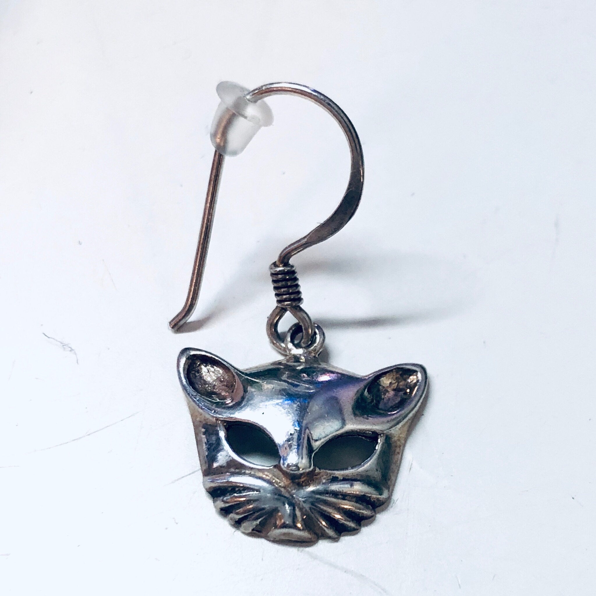 Vintage silver cat mask dangle earrings with cut-out design and blue tint, small and cute kitty cat themed jewelry.