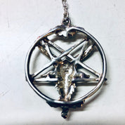 Alt text: Vintage silver necklace featuring a pentagram pendant with a goat head figure, dangling from a delicate chain, Gothic jewelry perfect for Valentine's Day or witch-inspired looks.