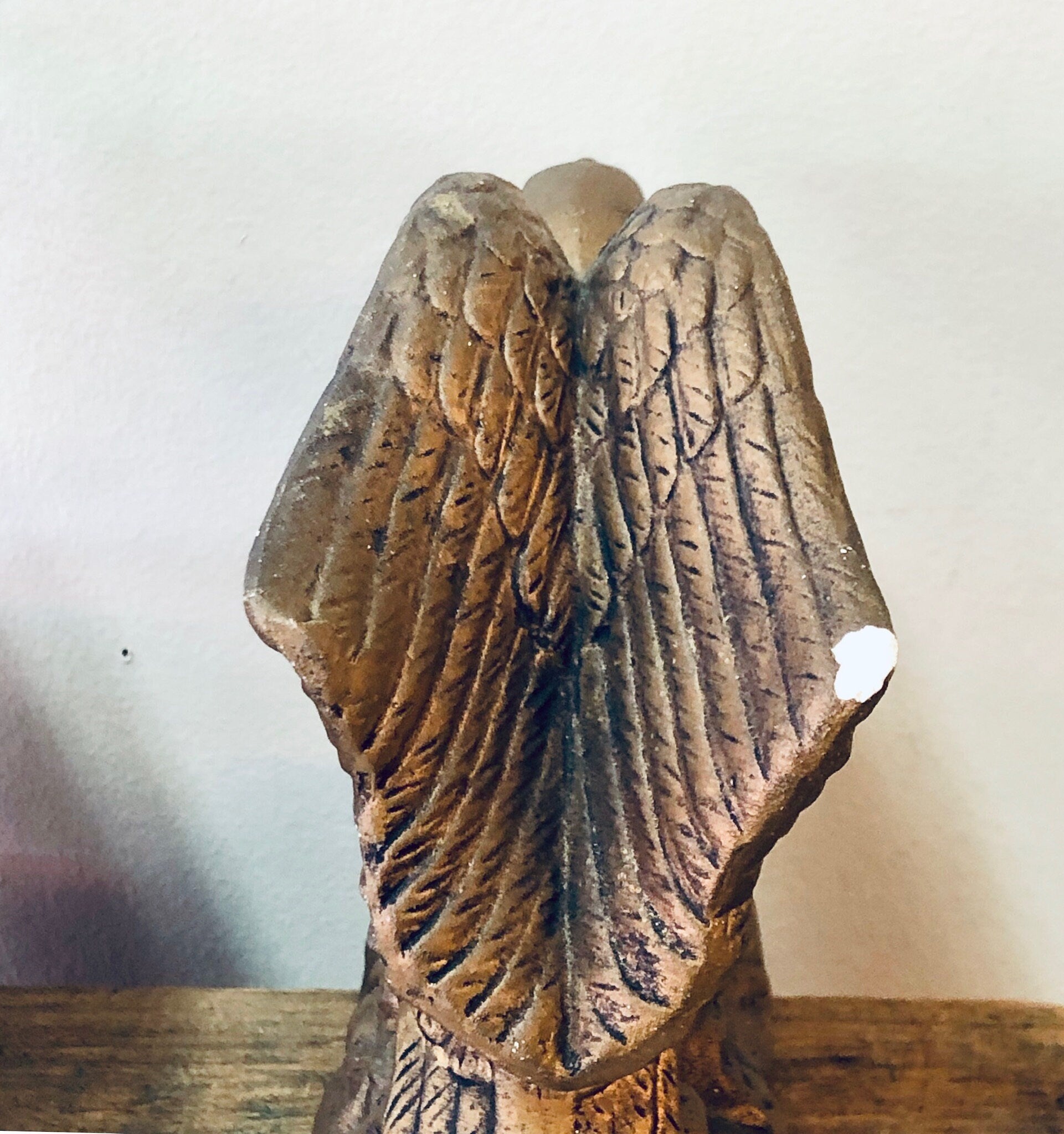 A pair of vintage ceramic eagle bookends with detailed feather textures in a golden brown finish, wings spread as if soaring, positioned on a wooden surface.