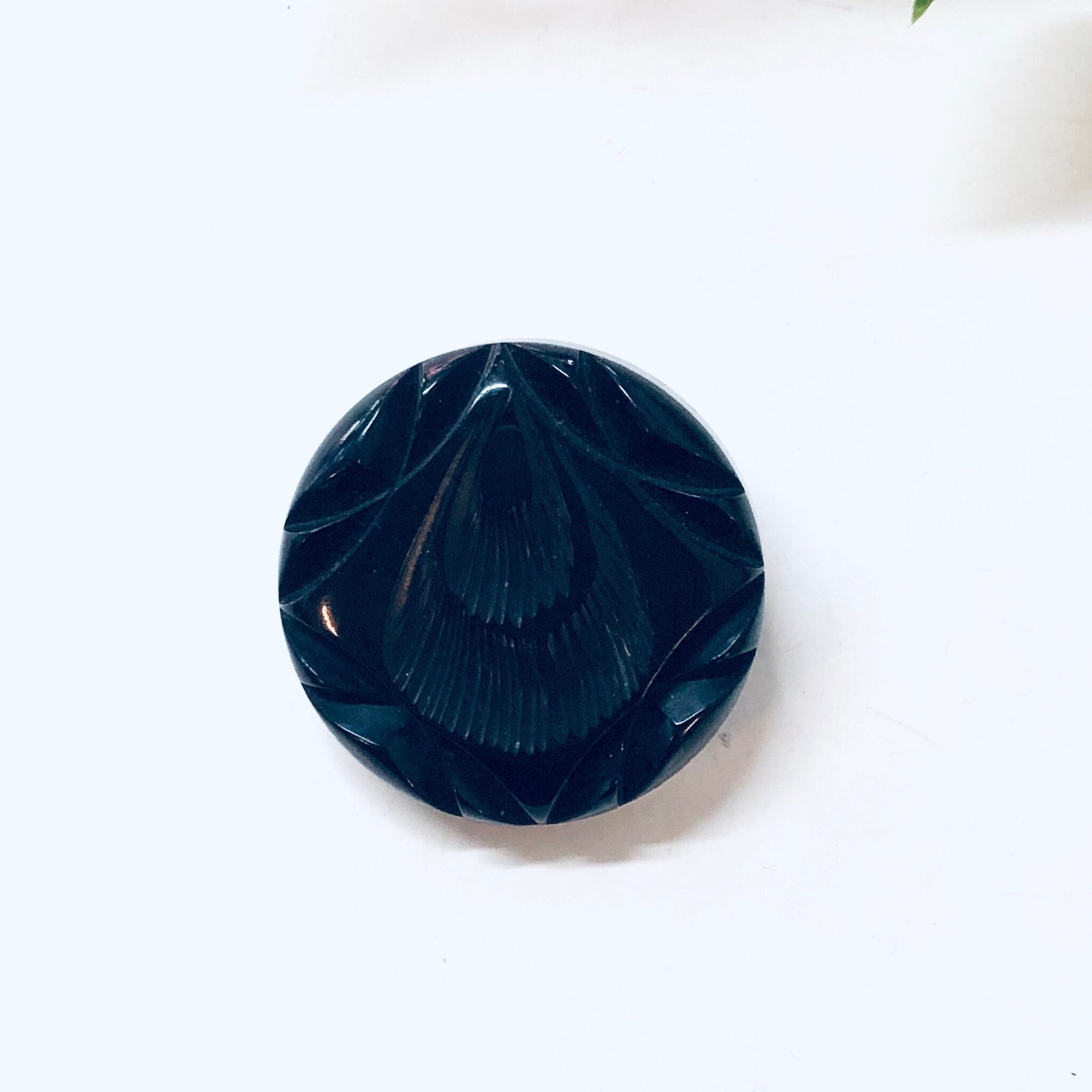 Vintage black carved Bakelite mourning brooch from the 1930s, round pin shape with intricate carved details