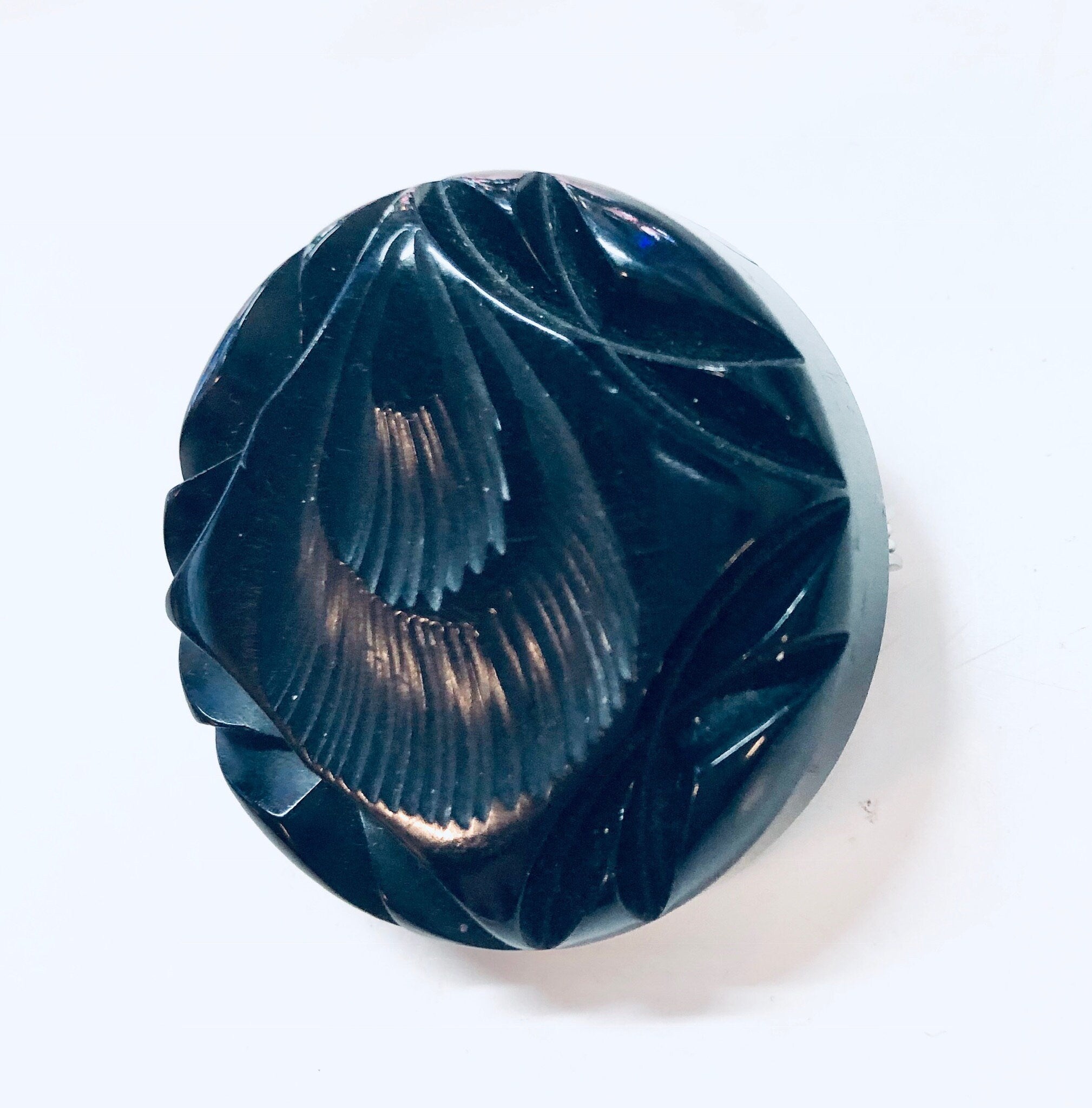 Vintage carved black Bakelite mourning brooch pin from the 1930s with textured swirl design.