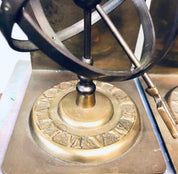 Vintage brass sundial bookends with Roman numerals on an antique base, unique spherical library or bookshelf decor.