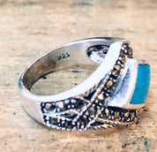 Vintage silver marcasite ring with turquoise stone, diamond-shaped design, sparkly 925 sterling statement jewelry on wooden background.