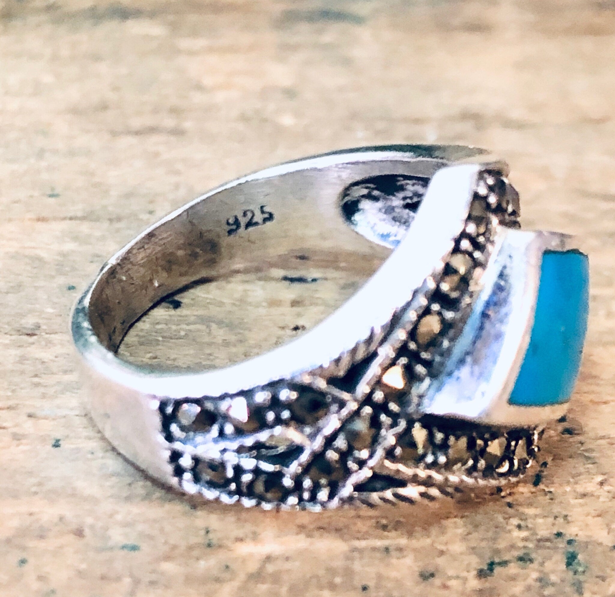Vintage silver marcasite ring with turquoise stone, diamond-shaped design, sparkly 925 sterling statement jewelry on wooden background.