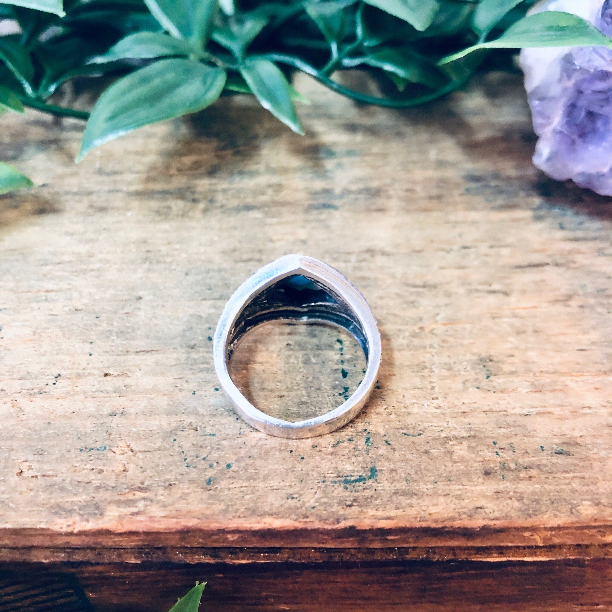 Vintage silver marcasite statement ring with turquoise stone, diamond-shaped design and sparkly appearance on a wooden surface, 925 hallmark visible.