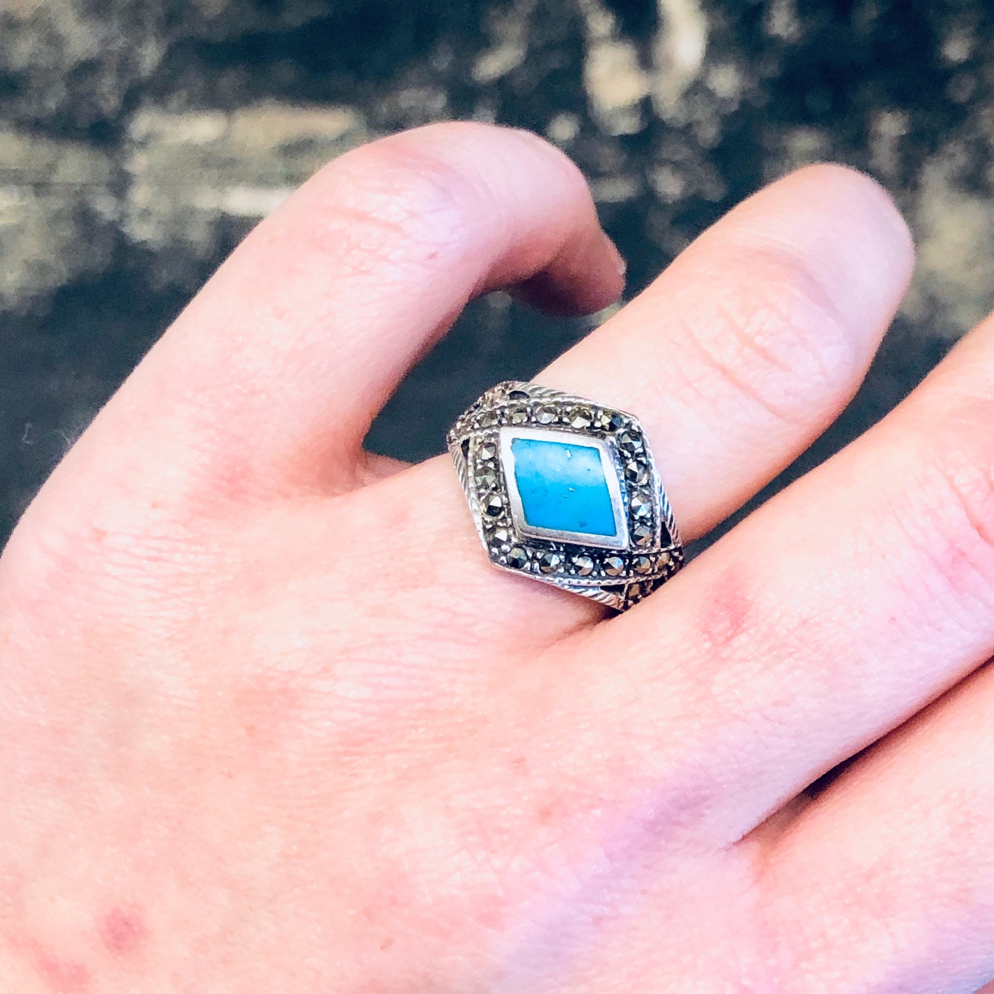 Vintage silver and turquoise marcasite statement ring on finger, featuring a diamond-shaped blue stone set in a sparkly 925 silver band with intricate detailing.