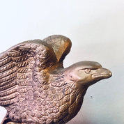 Vintage ceramic eagle bookends with intricate feather detailing in a gold tone, poised with wings spread as if soaring, perfect for decorating a bookshelf or library.