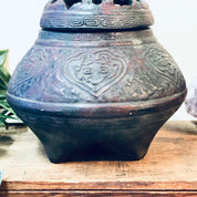 Ornate antique incense burner with intricate floral carvings on a weathered metal surface, featuring a decorative lidded design, perfect as a unique vintage home decor piece or housewarming gift.